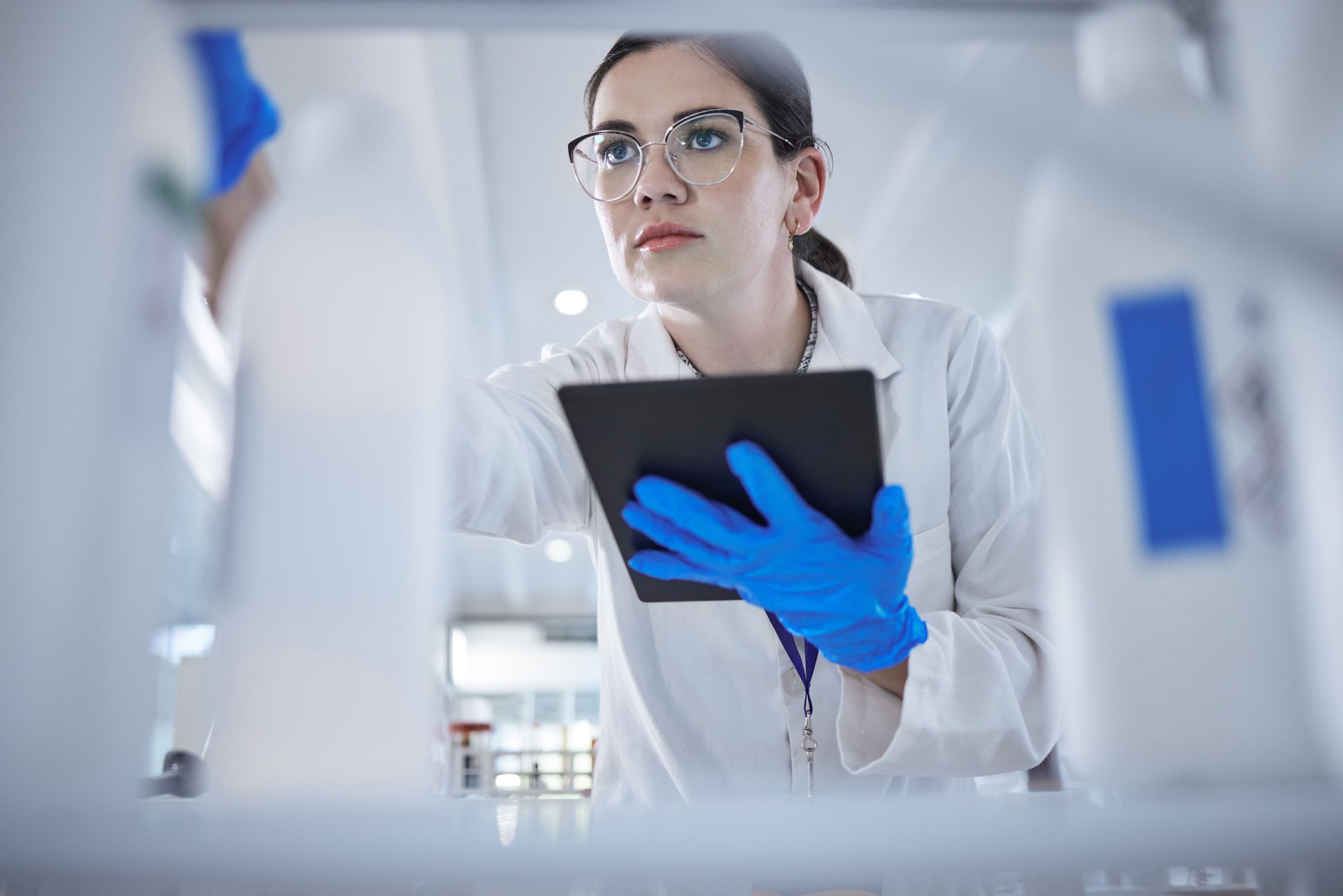 Woman, medical scientist and tablet in lab for test results check, future trial or science solution. Female person, digital device and thinking or review breakthrough hope, idea in biotechnology